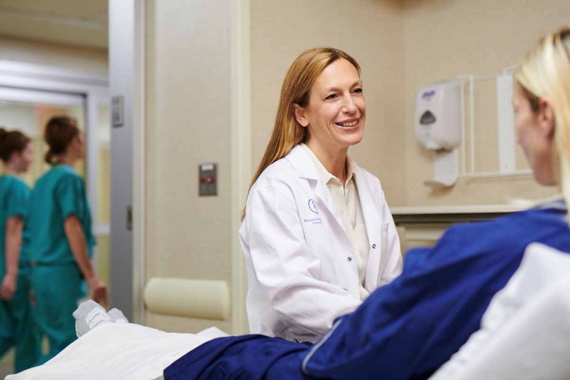 MSK esophageal cancer expert, Daniela Molena, sits with a female laying on a hospital bed