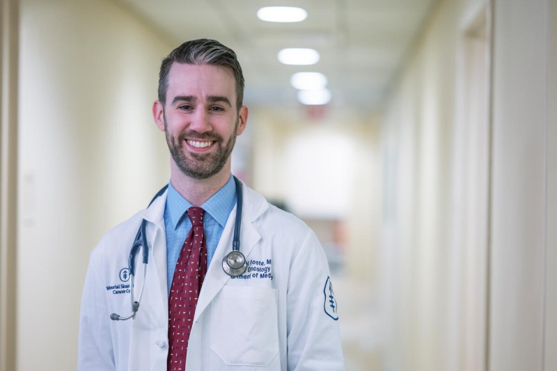 MSK medical oncologist Michael Foote, MD, is seen smiling in a hallway. 
