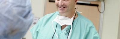 Surgeon and cervical cancer expert Nadeem Abu-Rustum dressed in surgical scrubs speaks to fellow doctor.