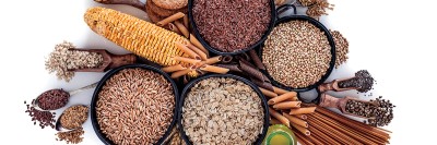 Fiber-rich foods including nuts, seeds, lentils, and whole-grain pasta arranged against white backdrop